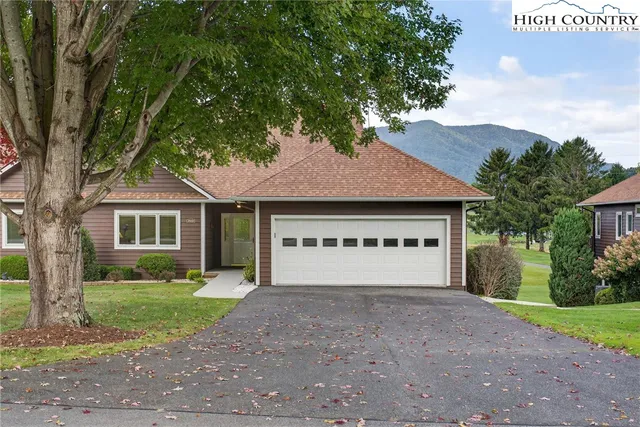 a view of house with yard and a garage