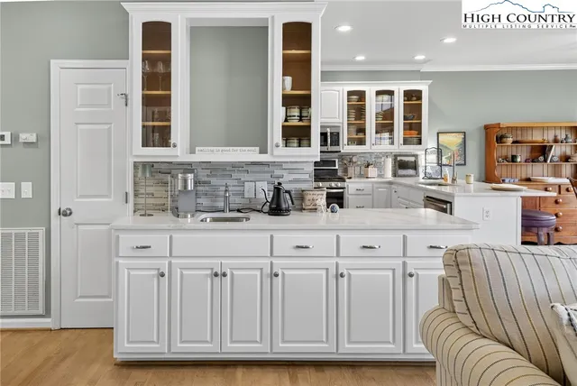 a kitchen with granite countertop a sink and white cabinets