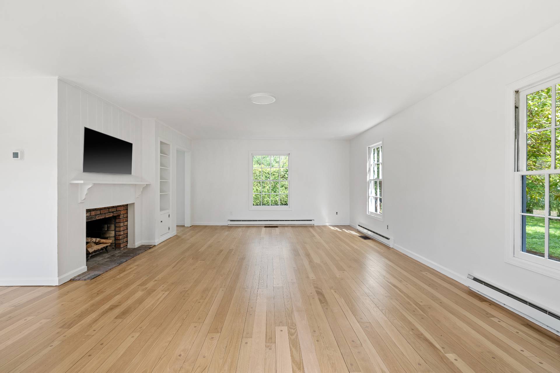 96 Audubon Avenue Bridgehampton, NY 11932 - Photo 13 of 25 a view of empty room with wooden floor and fireplace