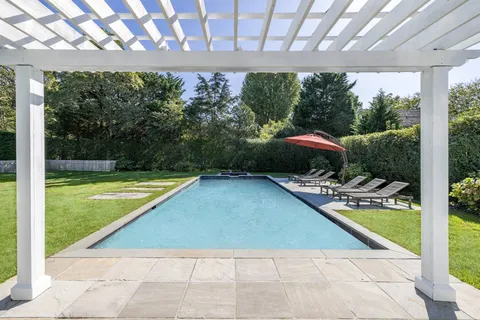 a view of swimming pool and deck in the backyard