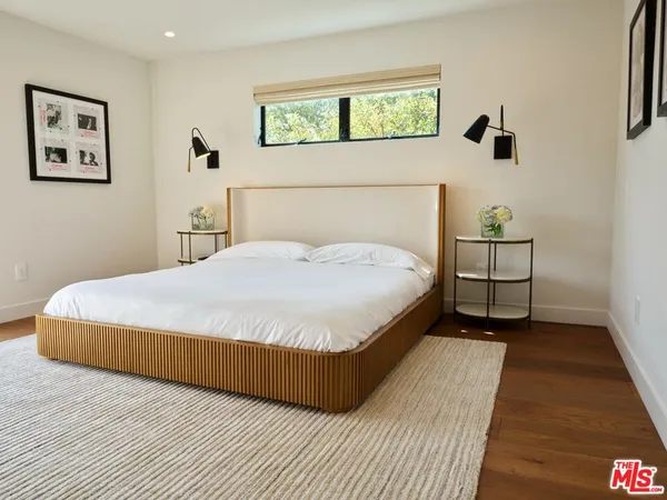 a bedroom with a bed and painting on the wall