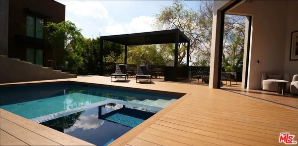 a swimming pool view with a seating space