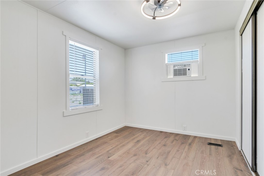 975 California Street, Unit 72 Calimesa, CA 92320 - Photo 17 of 23 an empty room with wooden floor and windows