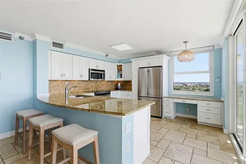 a kitchen with stainless steel appliances granite countertop a refrigerator sink and stove