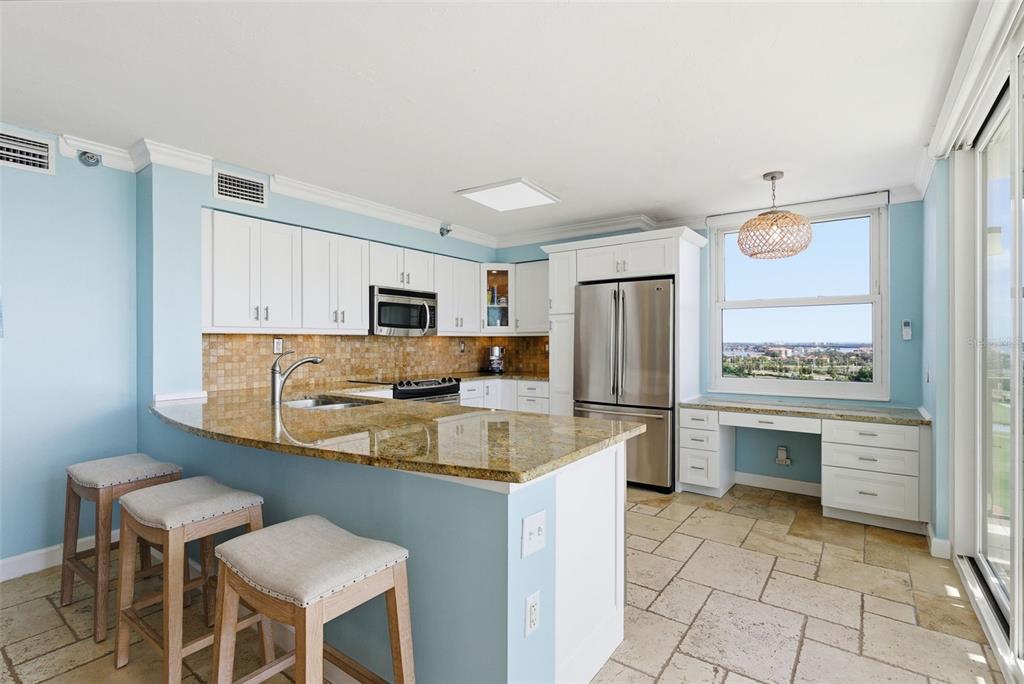 6265 Sun Boulevard, Unit 1204 St. Petersburg, FL 33715 - Photo 11 of 43 a kitchen with a refrigerator and a stove top oven