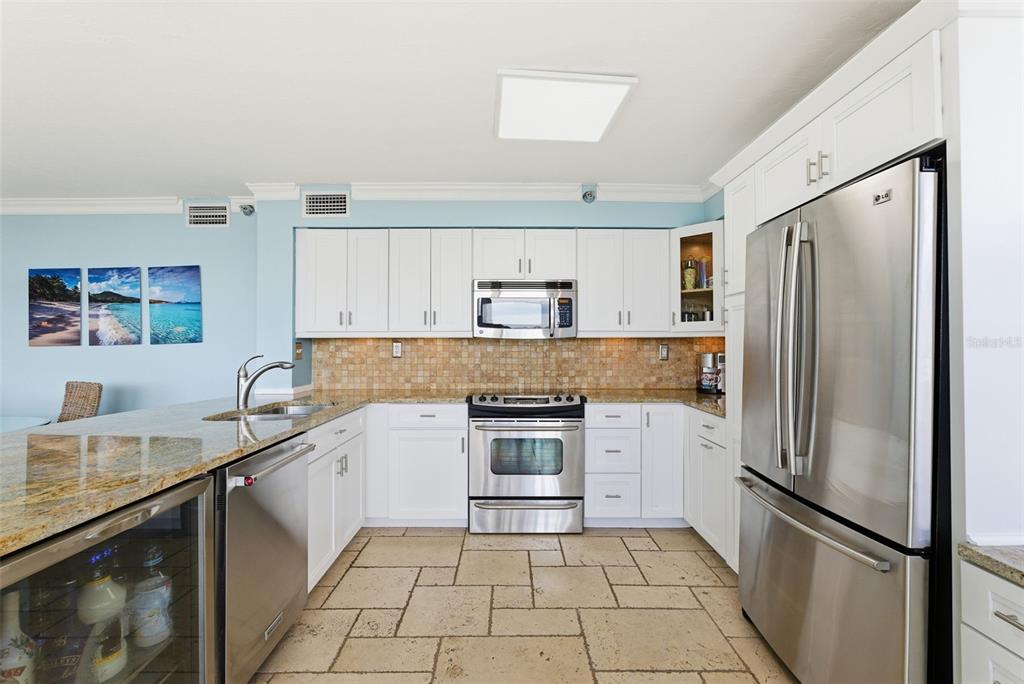 6265 Sun Boulevard, Unit 1204 St. Petersburg, FL 33715 - Photo 12 of 43 a kitchen with stainless steel appliances granite countertop a refrigerator sink and stove