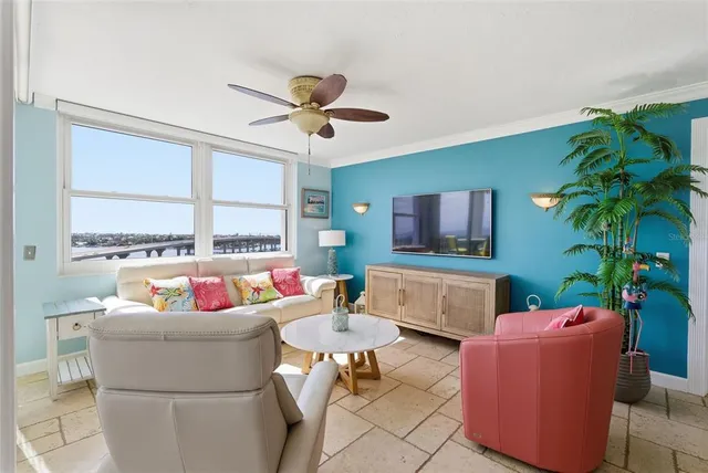 a living room with furniture kitchen view and a chandelier