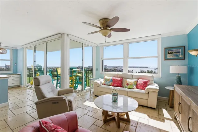 a living room with furniture a flat screen tv and a large window