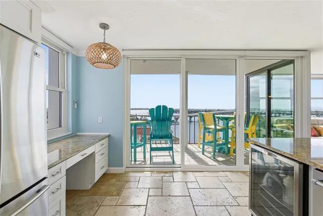 a view of a balcony with wooden chairs and ocean view