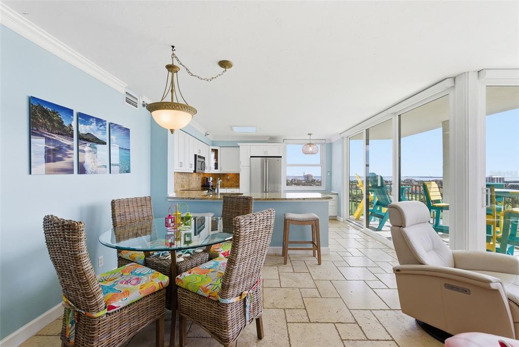 6265 Sun Boulevard, Unit 1204 St. Petersburg, FL 33715 - Photo 9 of 43 a living room with furniture and a dining table with kitchen appliances