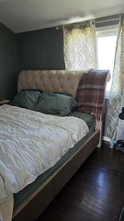 a bedroom with bed and a flat tv screen