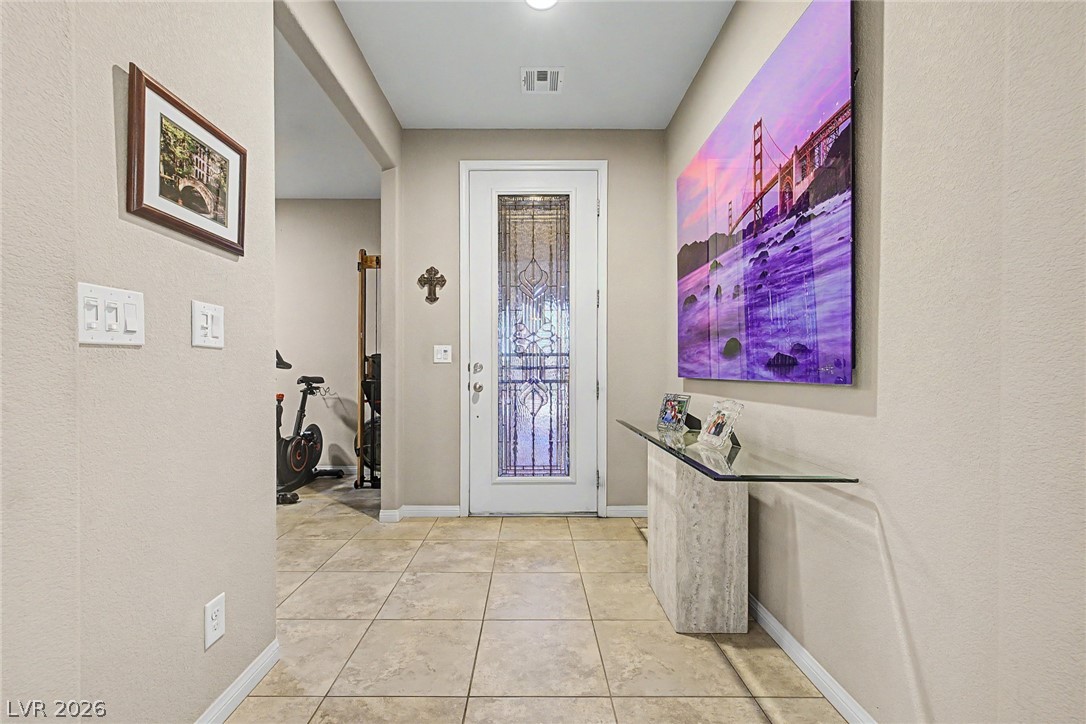 7415 Campbell Ranch Avenue Las Vegas, NV 89179 - Photo 11 of 52 A well-lit entry hall features tiled flooring and a door with decorative glass.