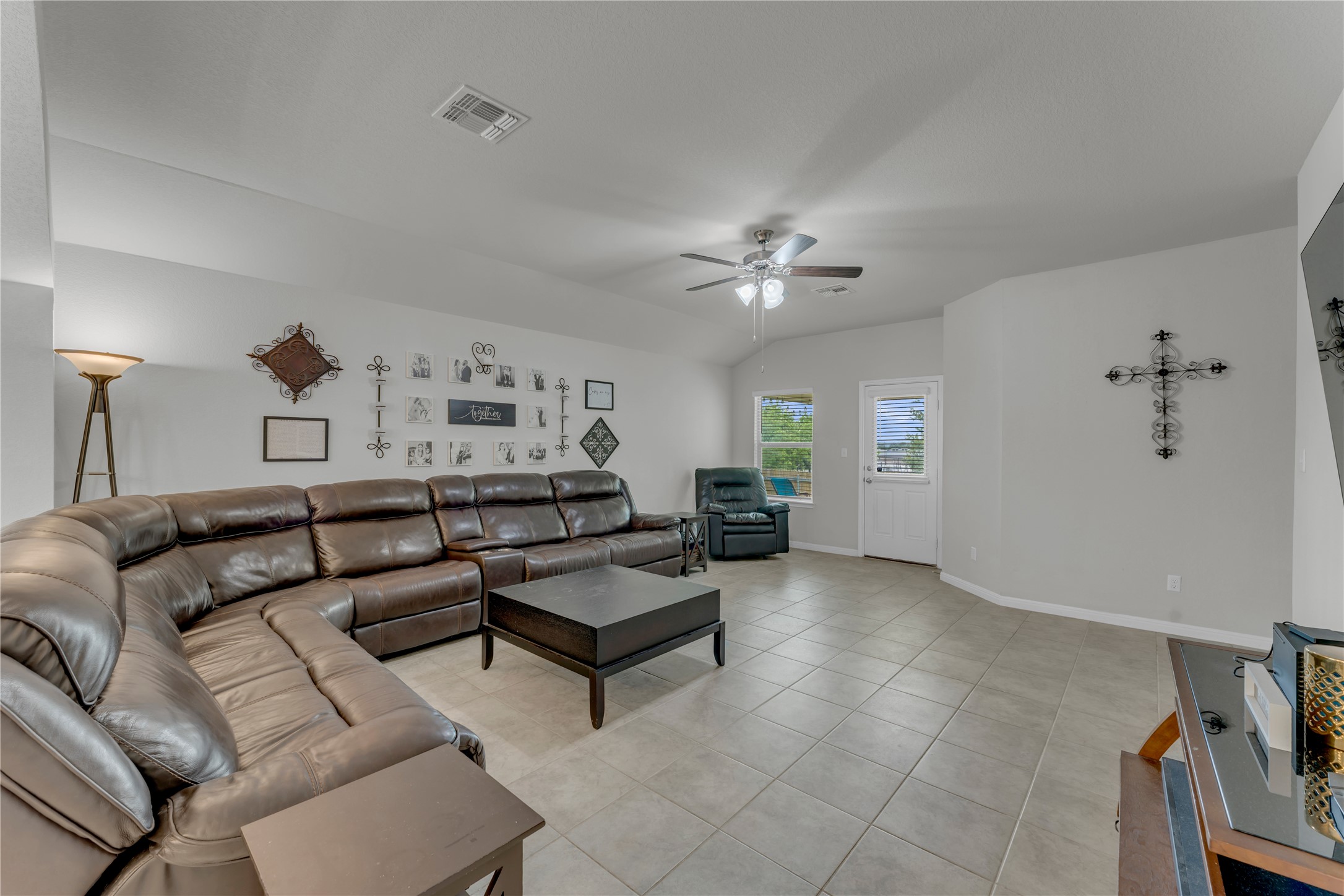 132 Cinnamon Loop Burnet, TX 78611 - Photo 9 of 27 Spacious living area featuring tiled flooring, a ceiling fan with integrated lighting, and multiple windows for natural light