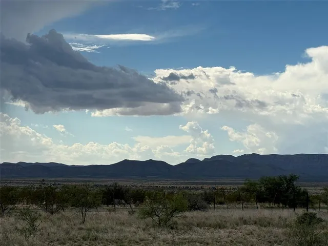 a view of a big house with a yard and mountain view