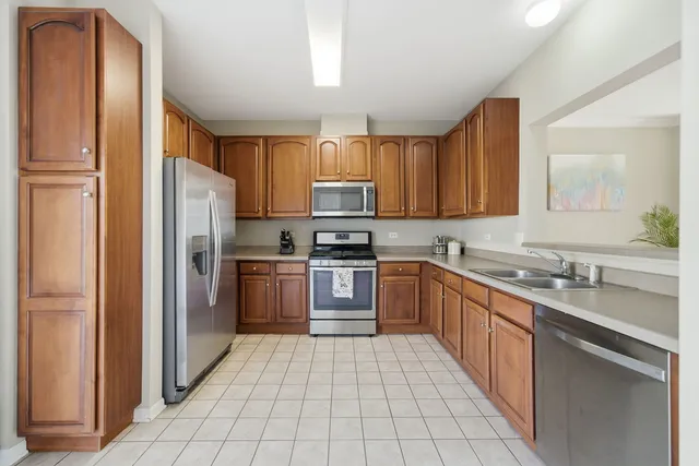 a kitchen with stainless steel appliances granite countertop a refrigerator and a stove top oven