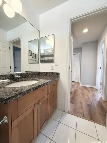 a bathroom with a granite countertop sink and a mirror