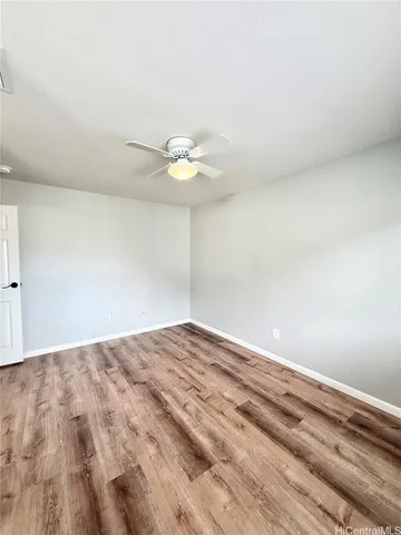 a view of a big room with wooden floor and a chandelier fan
