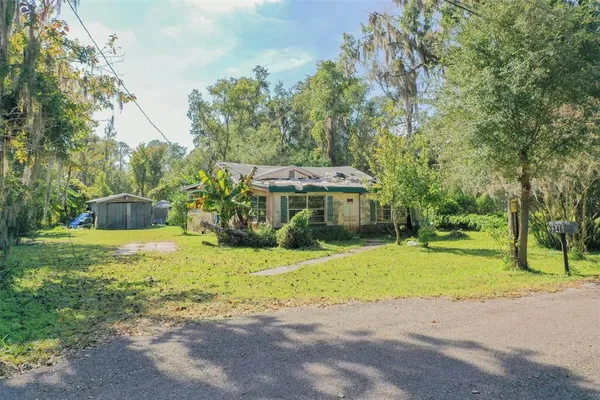 a view of a house with yard and sitting area