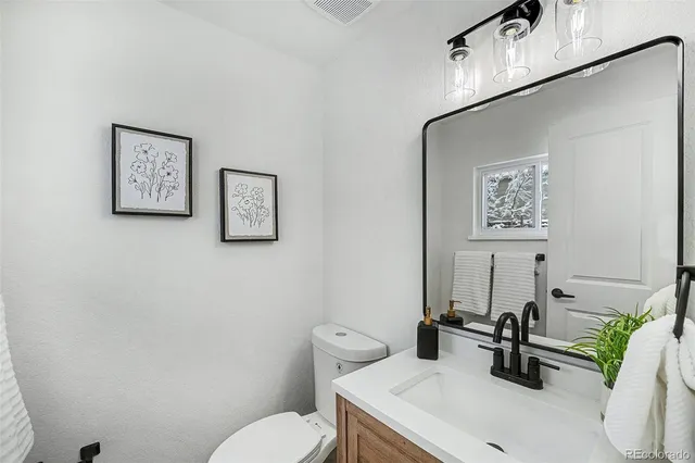 a bathroom with a toilet a sink and a mirror