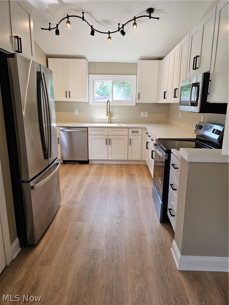 1147 Mayfield Ridge Road Cleveland, OH 44124 - Photo 5 of 23 Kitchen featuring range, light hardwood / wood-style flooring, refrigerator, dishwasher, and white cabinets