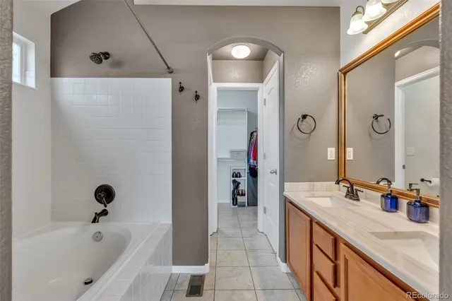 a bathroom with a tub sink and mirror