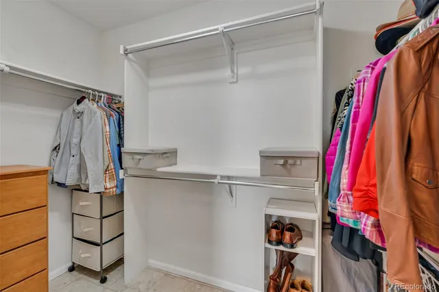a view of walk in closet with clothes and shoes