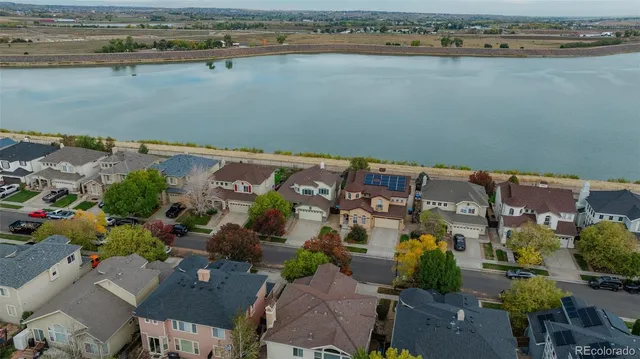 an aerial view of ocean and residential houses with outdoor space