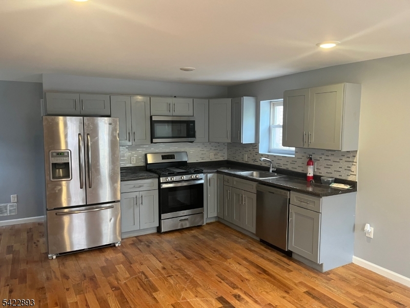 58 Wright Street, Unit 2 Newark, NJ 07114 - Photo 1 of 9 a kitchen with granite countertop a refrigerator and a stove top oven