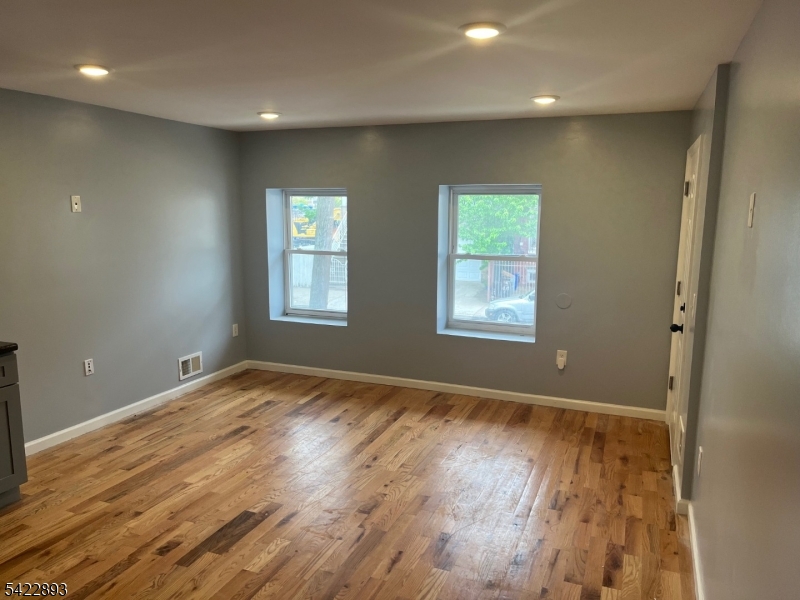 58 Wright Street, Unit 2 Newark, NJ 07114 - Photo 2 of 9 an empty room with wooden floor and windows