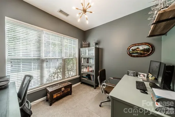 a view of a workspace with furniture and a window