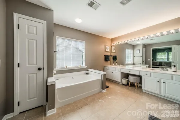 a large spacious bathroom with a large tub shower and sink
