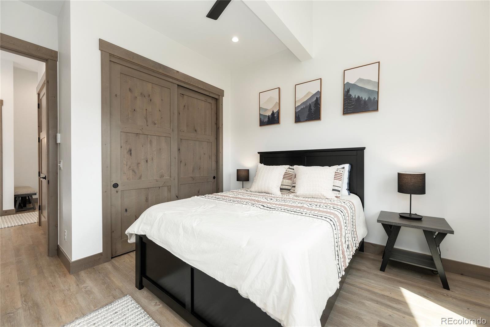 96 Meadow Trail, Unit G304 Fraser, CO 80442 - Photo 19 of 38 a bedroom with a bed and a night stand