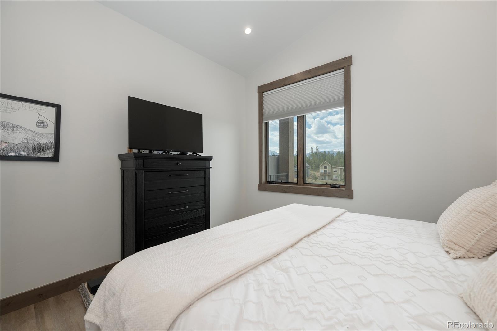 96 Meadow Trail, Unit G304 Fraser, CO 80442 - Photo 25 of 38 a bedroom with a bed and a flat screen tv