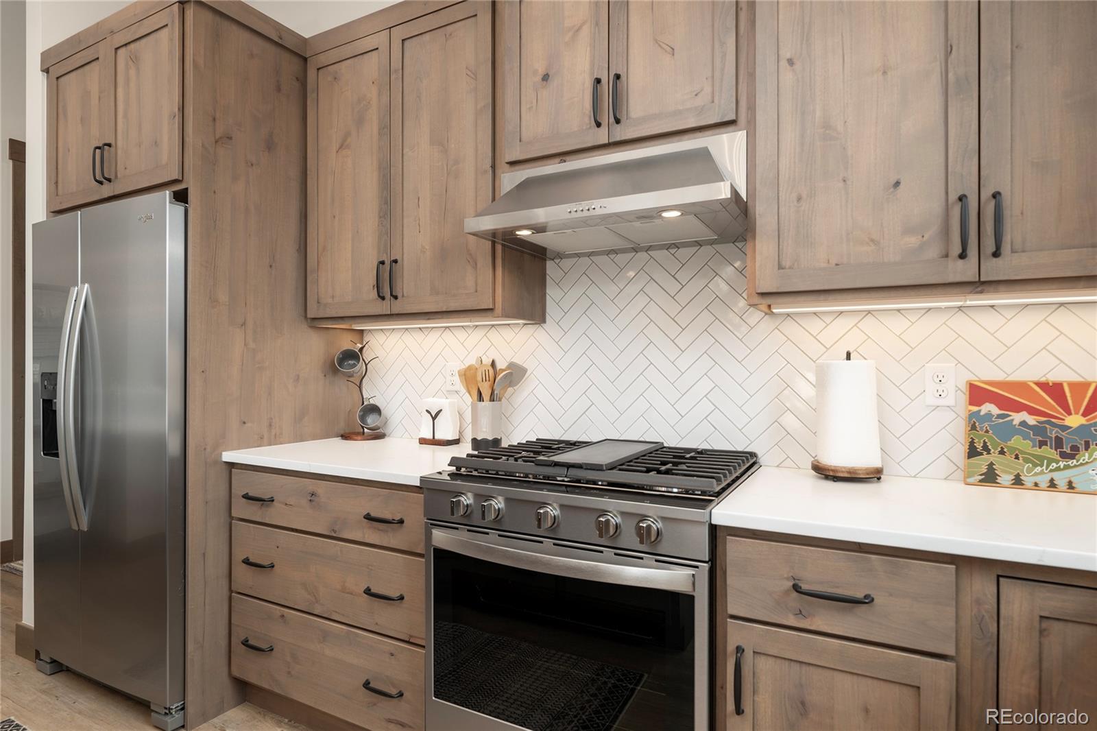 96 Meadow Trail, Unit G304 Fraser, CO 80442 - Photo 31 of 38 a kitchen with stainless steel appliances granite countertop a stove a refrigerator and a cabinets