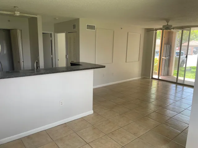 a kitchen with granite countertop a stove a sink and a refrigerator
