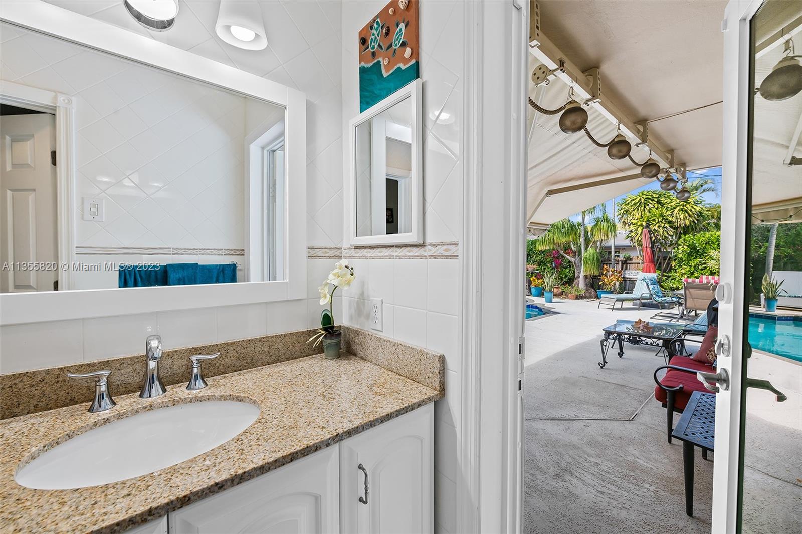 3731 Thomas Street Hollywood, FL 33021 - Photo 17 of 21 a bathroom with a granite countertop sink a mirror and a window