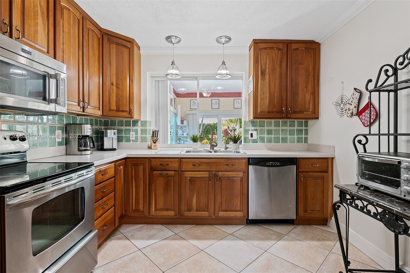 3731 Thomas Street Hollywood, FL 33021 - Photo 8 of 21 a kitchen with stainless steel appliances granite countertop a stove and a sink