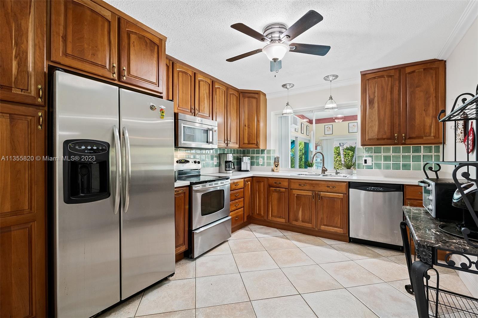 3731 Thomas Street Hollywood, FL 33021 - Photo 9 of 21 a kitchen with stainless steel appliances granite countertop a refrigerator a stove a sink and dishwasher