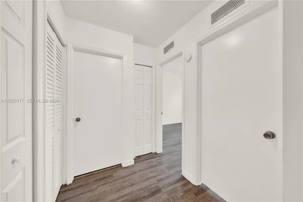 a view of a hallway with wooden floor