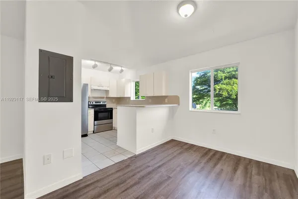 a kitchen with stainless steel appliances granite countertop a refrigerator a sink dishwasher a stove and white countertops with wooden floor