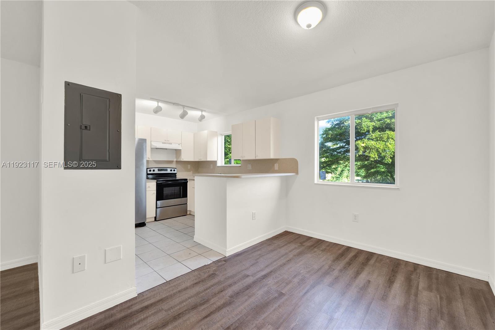 3385 Northeast 10th Street, Unit 201 Homestead, FL 33033 - Photo 3 of 15 a kitchen with stainless steel appliances granite countertop a refrigerator a sink dishwasher a stove and white countertops with wooden floor