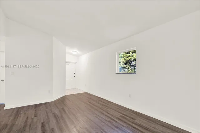 a view of an empty room with wooden floor