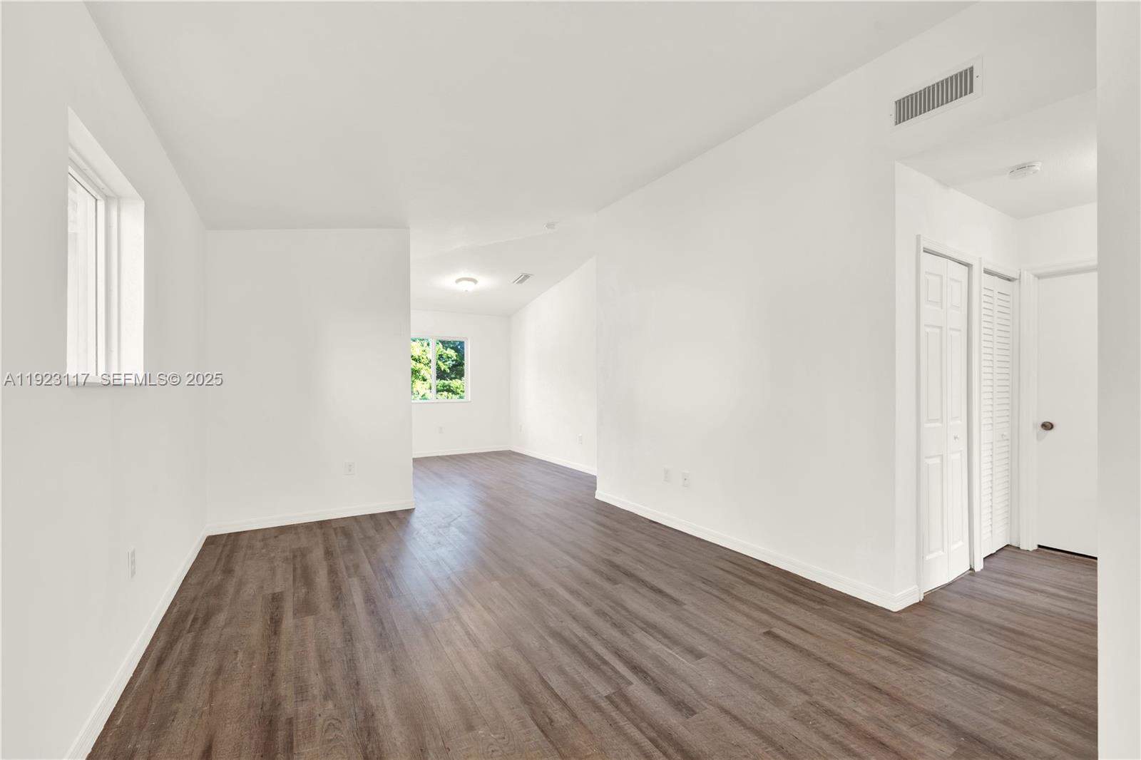 3385 Northeast 10th Street, Unit 201 Homestead, FL 33033 - Photo 7 of 15 an empty room with wooden floor and windows