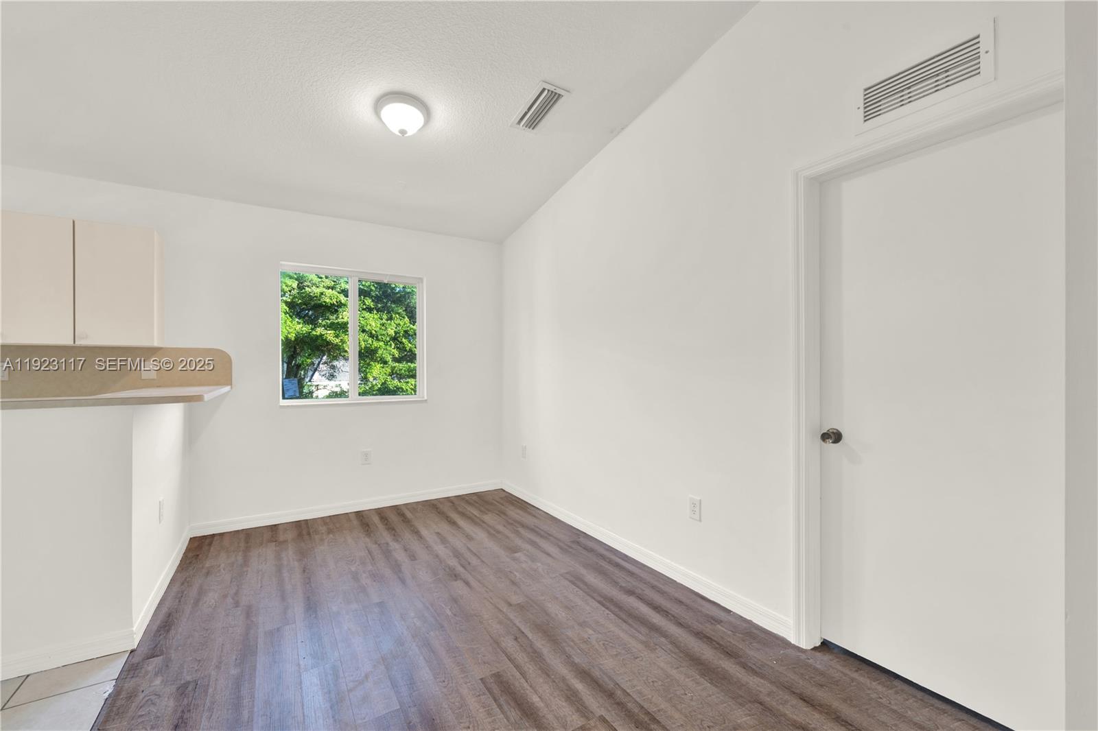 3385 Northeast 10th Street, Unit 201 Homestead, FL 33033 - Photo 8 of 15 a view of an empty room with wooden floor and a window