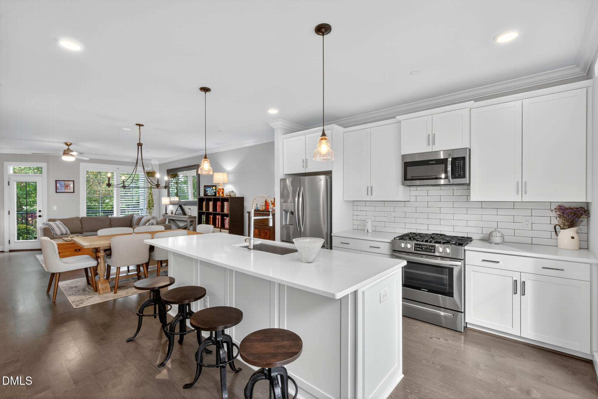 1610 Draper View Loop, Unit 102 Raleigh, NC 27608 - Photo 3 of 40 a open kitchen with stainless steel appliances granite countertop a stove a sink a kitchen island with a dining table and chairs