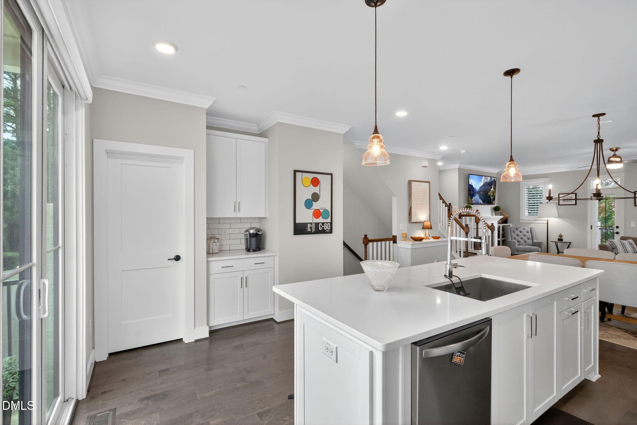 1610 Draper View Loop, Unit 102 Raleigh, NC 27608 - Photo 5 of 40 a kitchen with a sink a center island a counter space and a view of living room