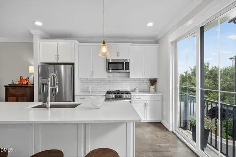 a kitchen with a sink a center island a counter space and a view of living room