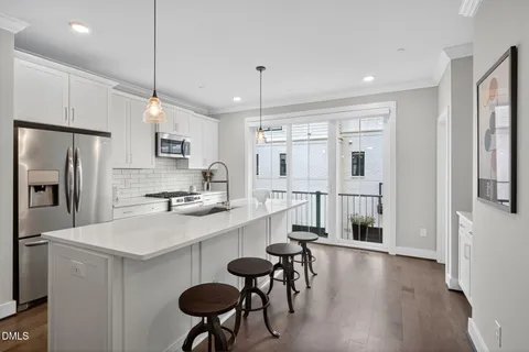 a kitchen with a sink a refrigerator and cabinets