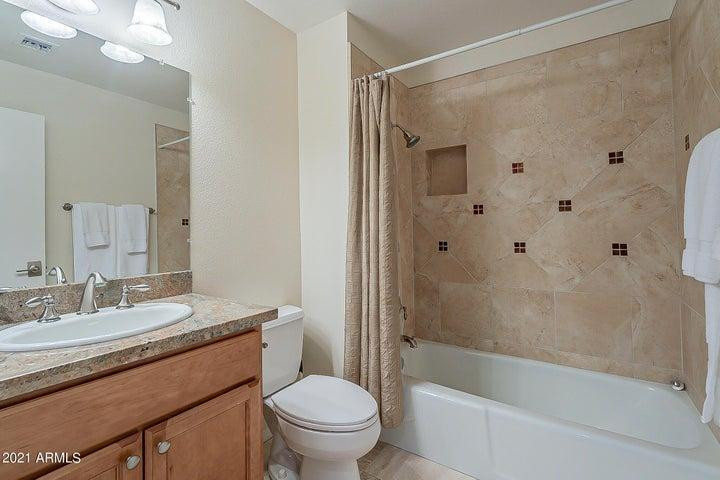 7700 East Gainey Ranch Road, Unit 153 Scottsdale, AZ 85258 - Photo 21 of 24 a bathroom with a granite countertop sink a toilet and shower