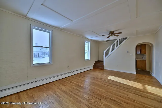 a view of empty room with wooden floor